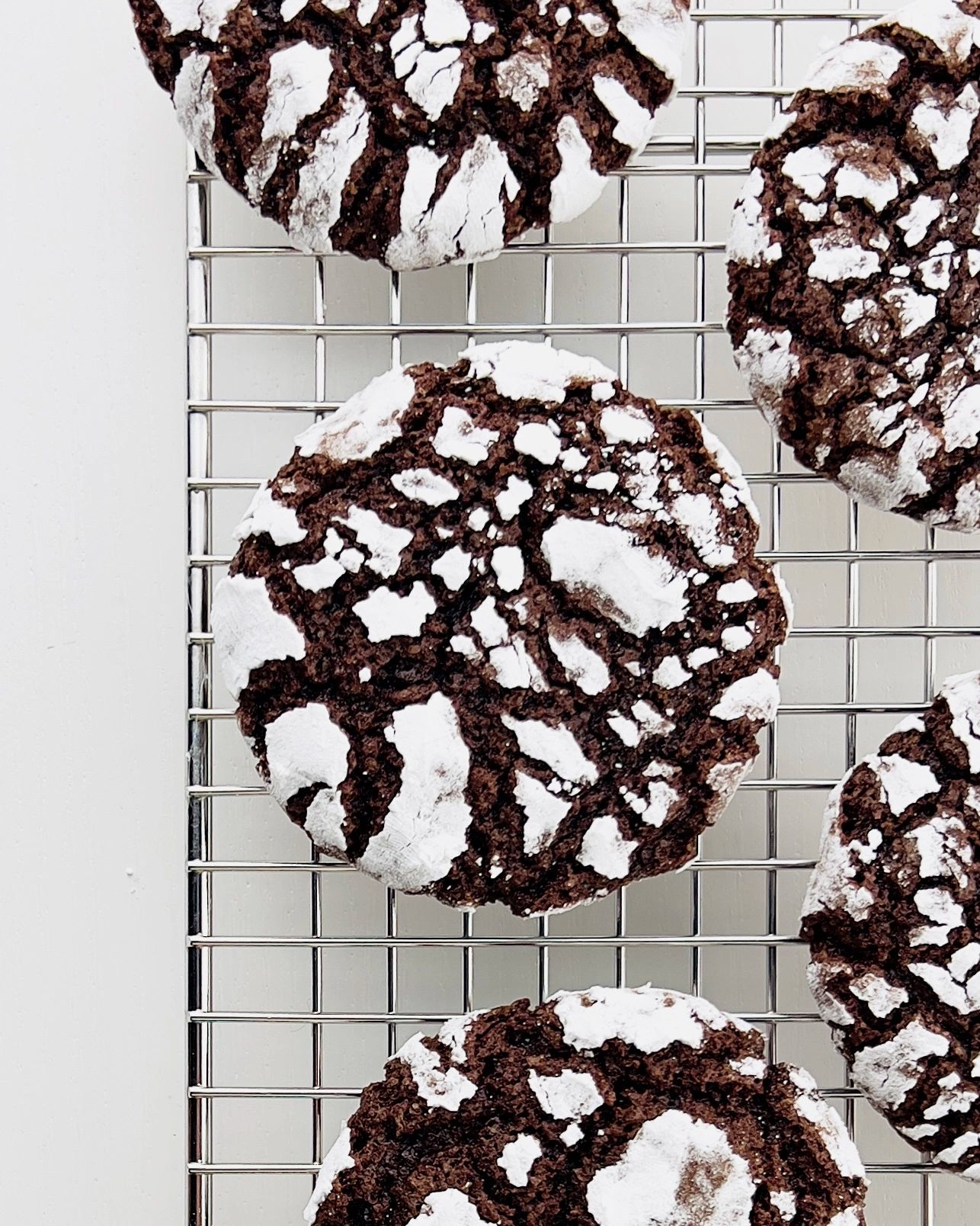 Close-up of chocolate-covered dates, one cut in half revealing the inside, on parchment paper with cocoa powder dusting.