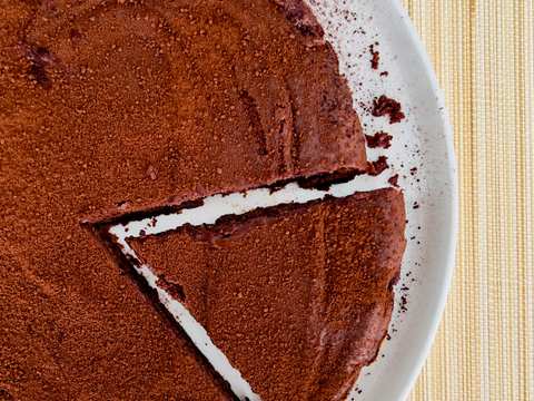 A slice of rich chocolate and ricotta cake, showcasing its moist texture and dark color.