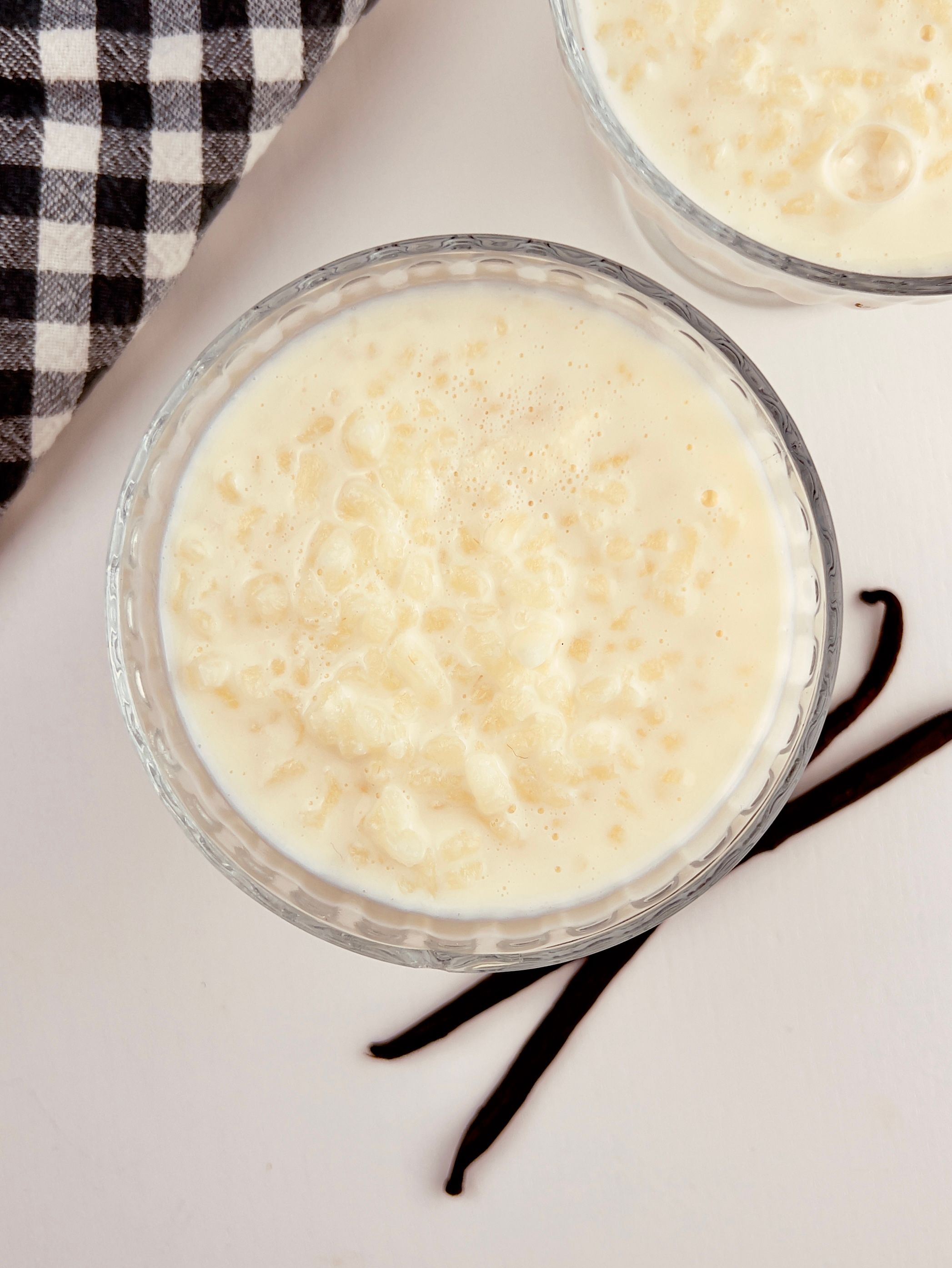 Creamy classic rice pudding in a bowl, sprinkled with cinnamon, with a spoon nearby.