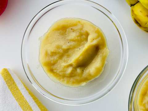 Delicious apple crumble with golden topping served in a white dish, with a scoop revealing warm apple filling.